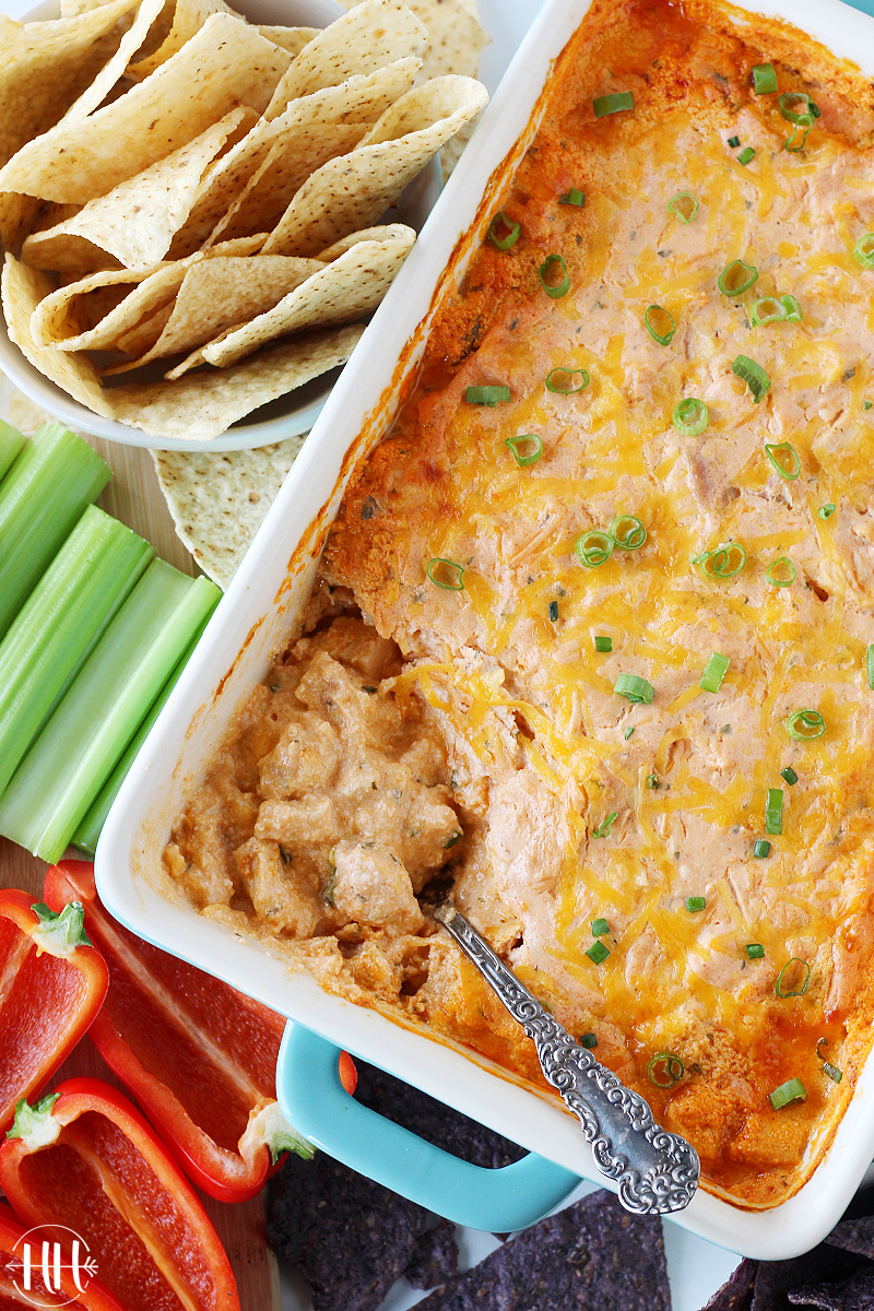 Overhead photo of creamy buffalo chicken dip with a spoon in it.