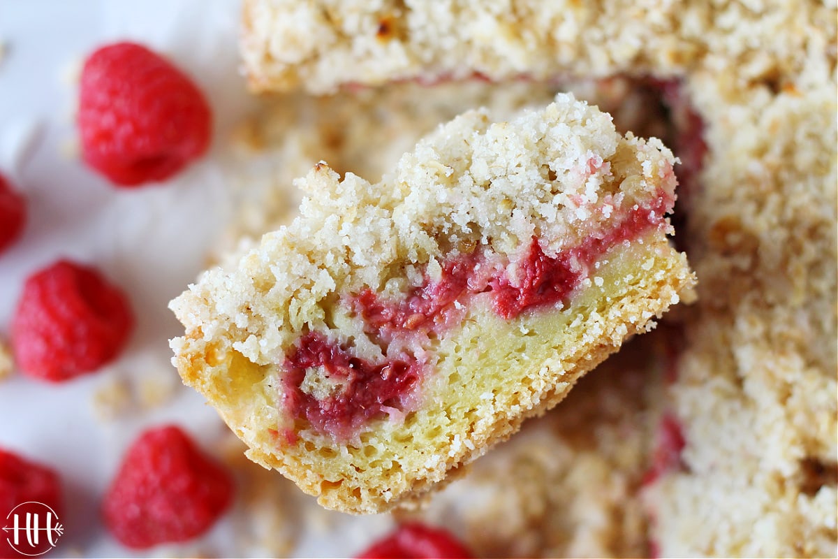 Up close photo of raspberry coffee cake with layers of crumble, fruit, cake.