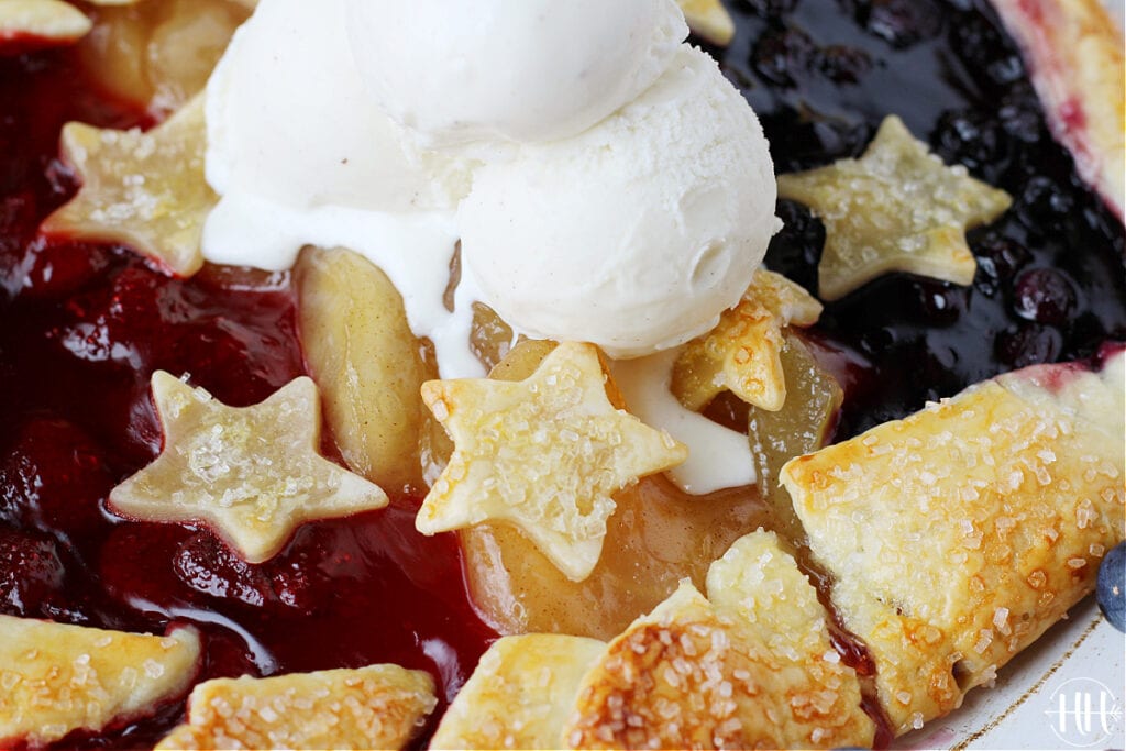 Small stars made of pie dough and topped with course sanding sugar on a patriotic galette. 