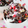 Valentine's Day Chocolate Pretzel Bark in a white bowl with pink and red M&Ms.