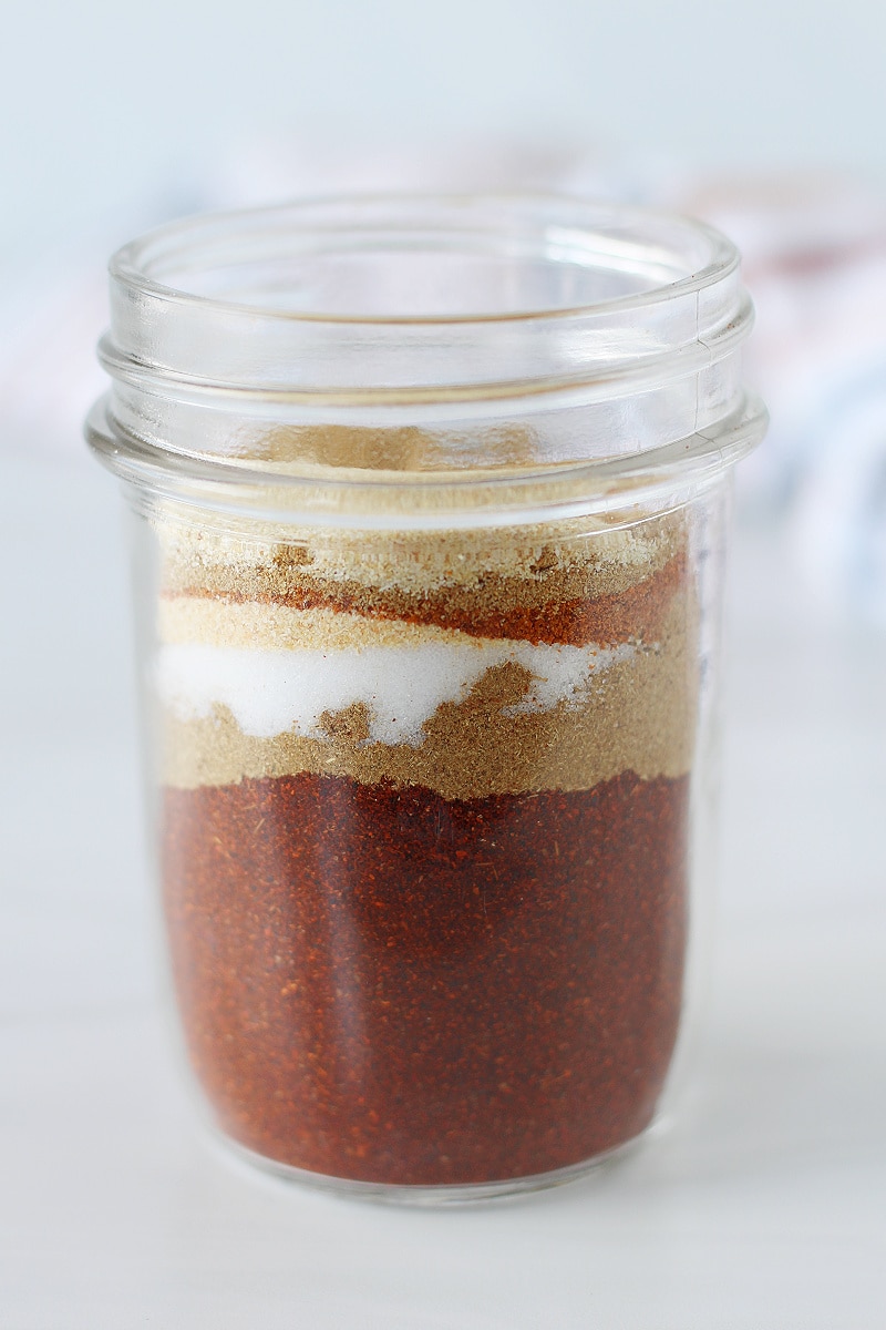 DIY taco seasoning mix ingredients layered in a mason jar.