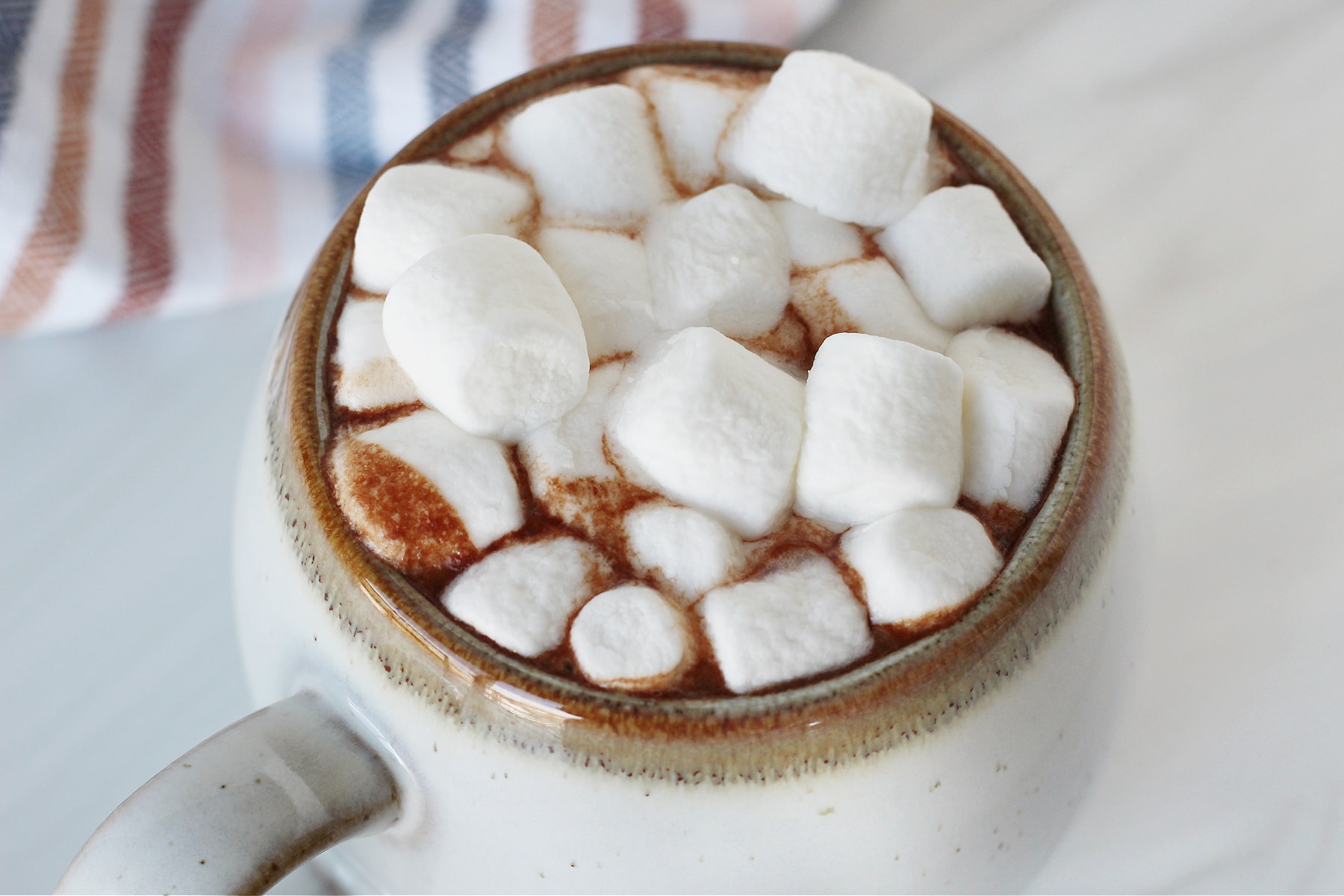 Up close photo of bone broth hot cocoa in a mug topped with marshmallows.