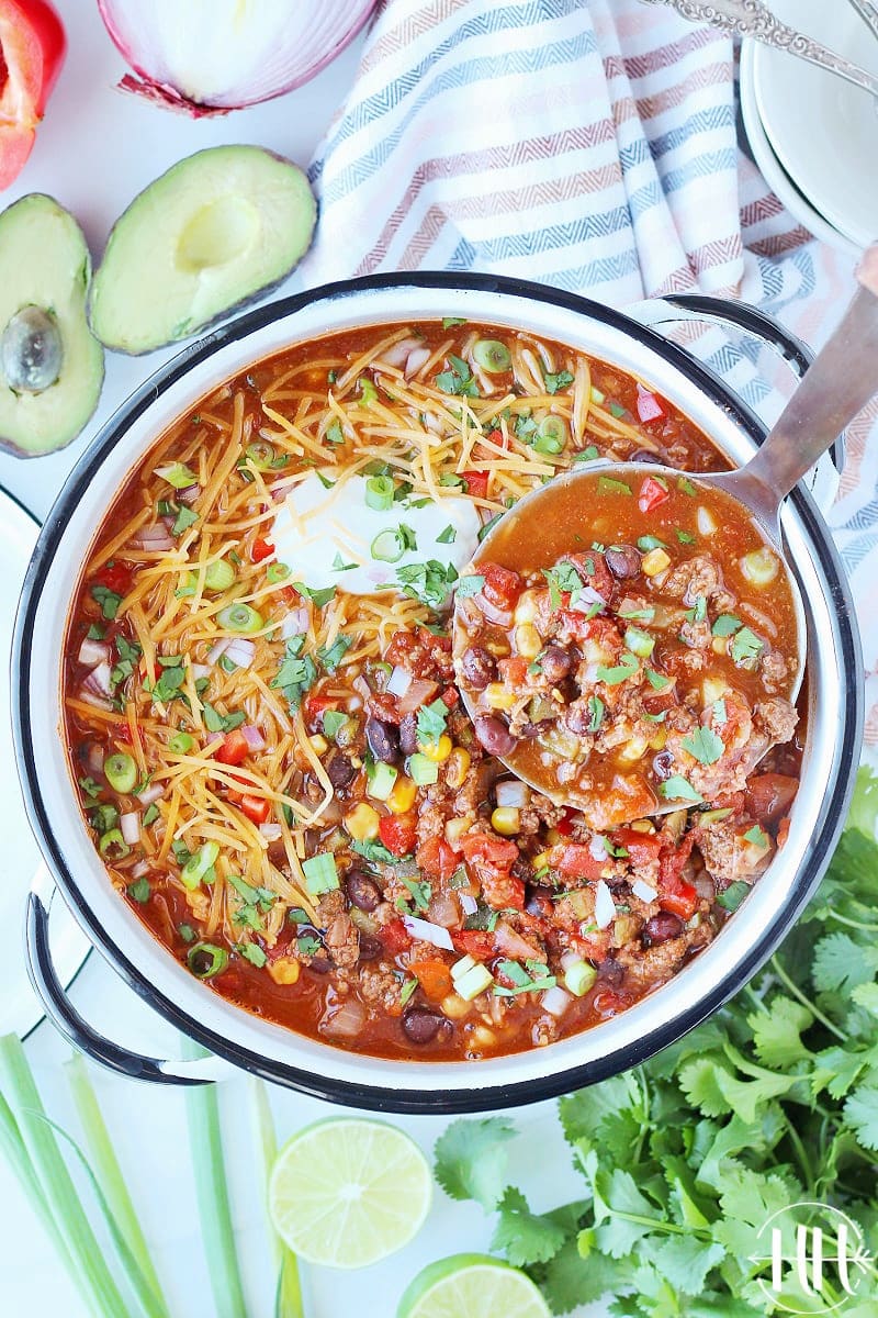 Overhead photo of one pot taco soup in a white pot with a silver ladle.
