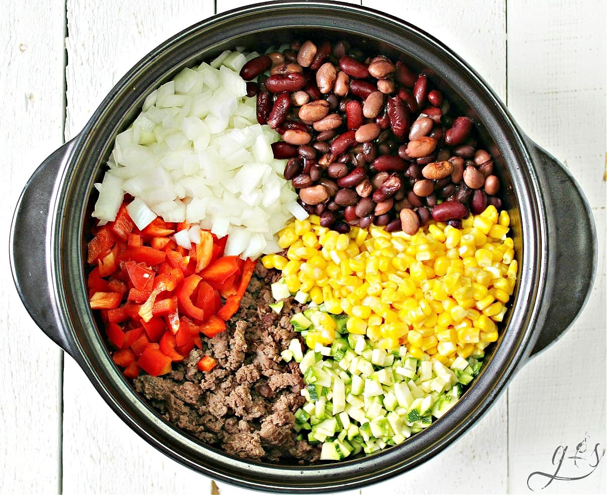 Overhead photo of individual taco soup ingredients in a black soup pot.