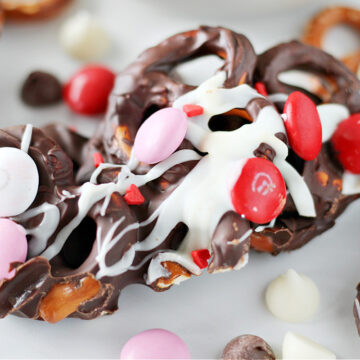 Up close photo of Valentine’s Day Chocolate Pretzel Bark drizzled with white chocolate and M&Ms.