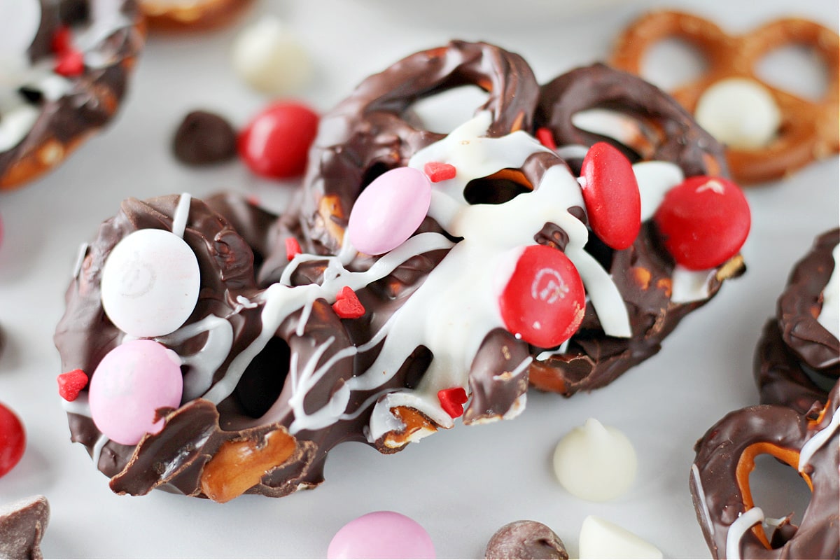Up close photo of Valentine’s Day Chocolate Pretzel Bark drizzled with white chocolate and M&Ms.