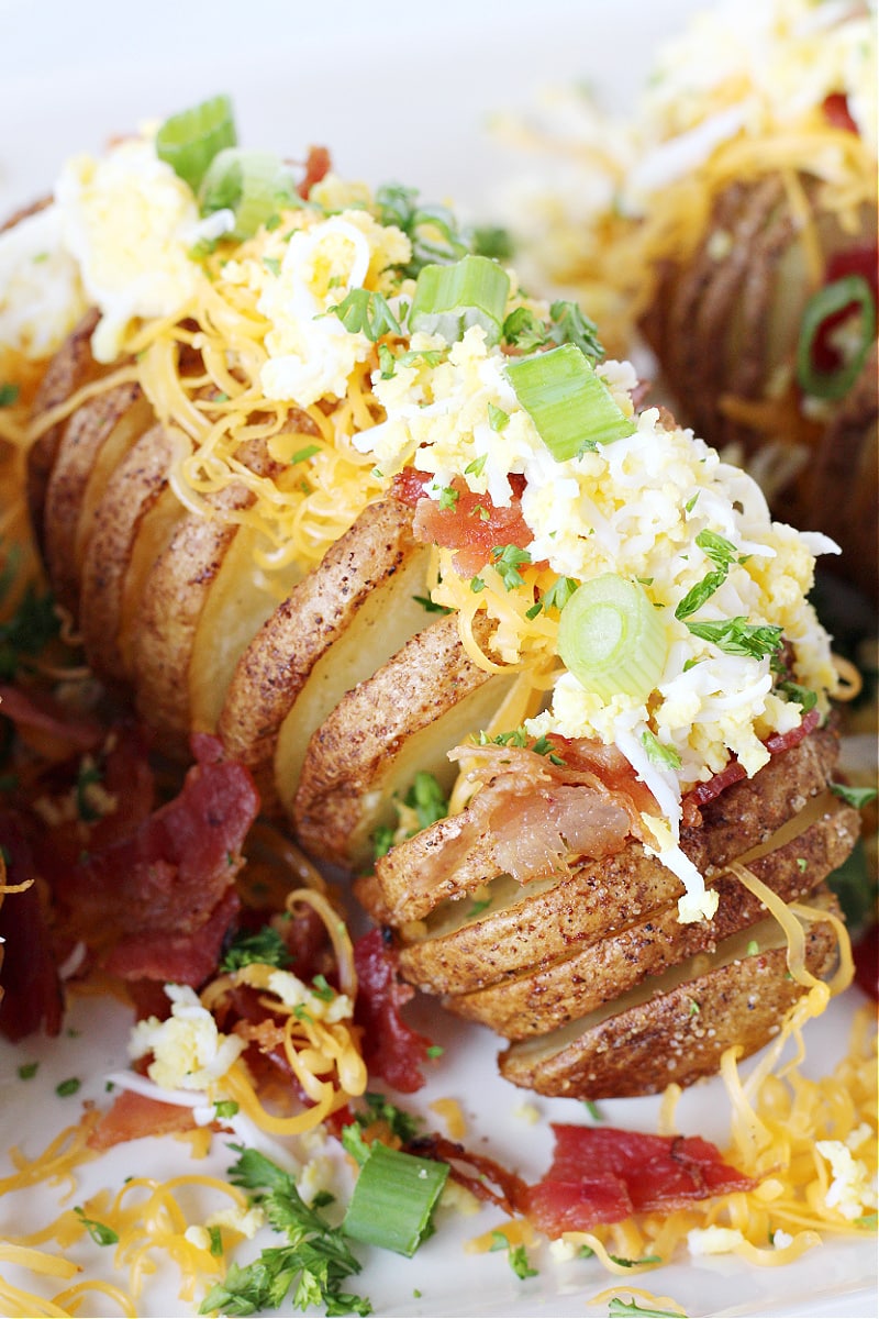 Air fried hasselback potato topped with grated eggs, green onion, bacon and cheese.
