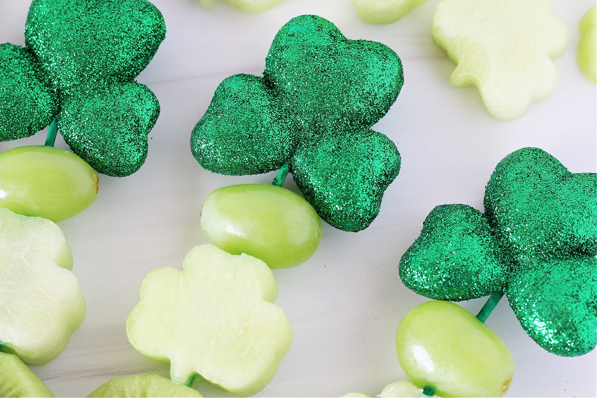 Up close photo of three St. Patrick's Day Fruit Kabobs on green skewers.