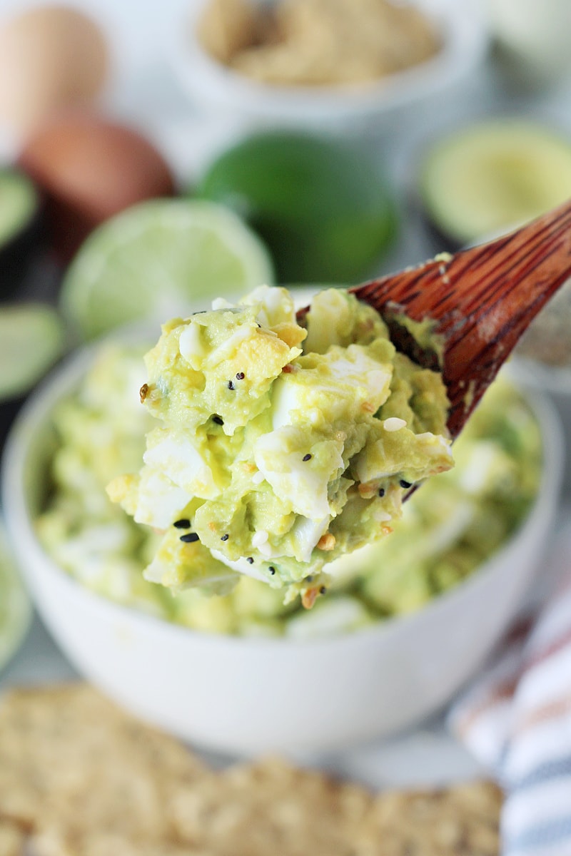 Homemade dairy free and gluten free Avocado Egg Salad on a wooden spoon.
