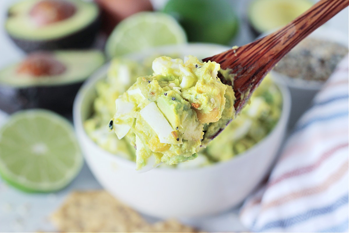 Homemade low carb Avocado Egg Salad on a wooden spoon.