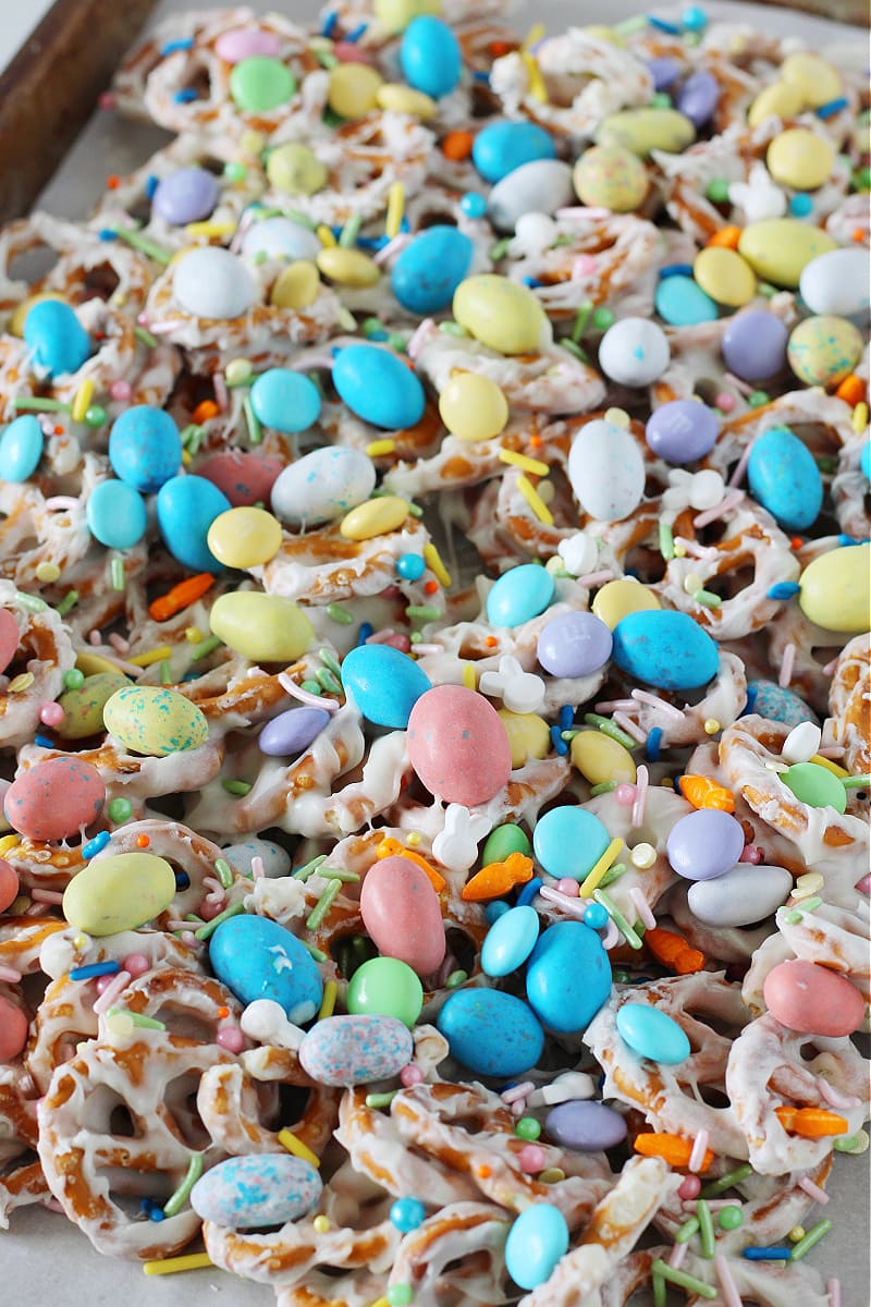 Easter White Chocolate Pretzel Bark on a sheet pan with pastel M&Ms and candies.