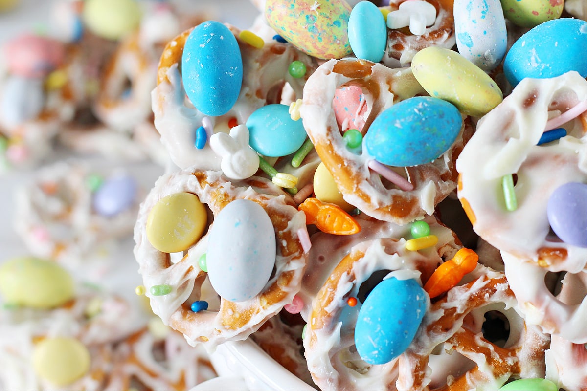 Up close photo of Easter Pretzel Bark with pastel Robin Eggs and carrot sprinkles.