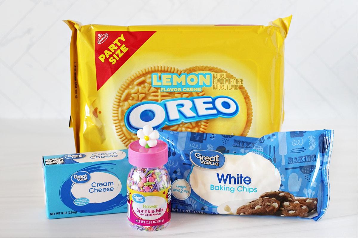 A container of lemon Oreos, block of cream cheese, white chocolate chips and spring sprinkles.