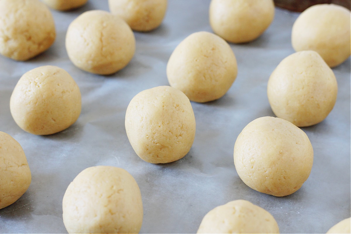 Lemon Oreo truffle balls on a sheet pan ready to be dipped in white chocolate.