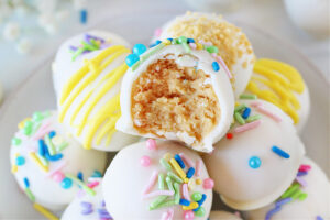 A lemon Oreo truffle with spring sprinkles and a bite removed.