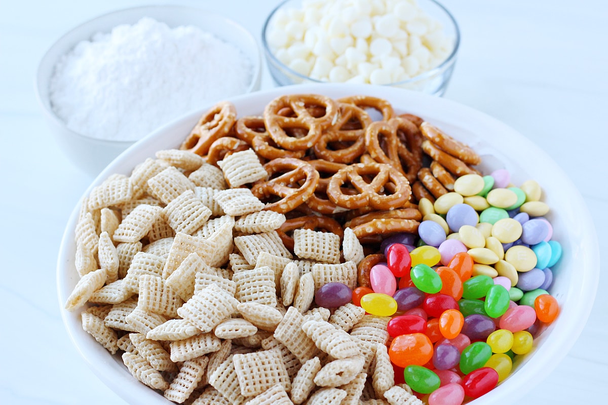 Ingredients for Easter Puppy Chow like Chex cereal, jelly beans and white chocolate chips.