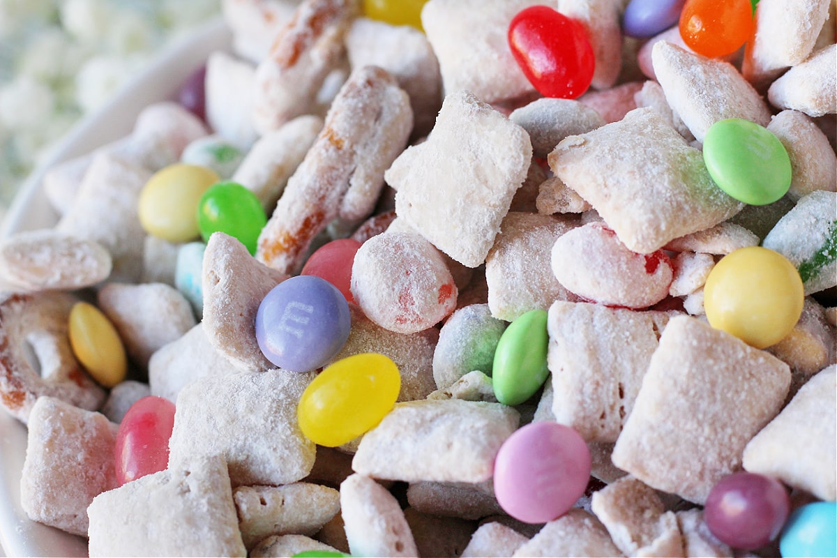 Up close photo of a Easter Puppy Chow recipe with pastel M&Ms and jelly beans.