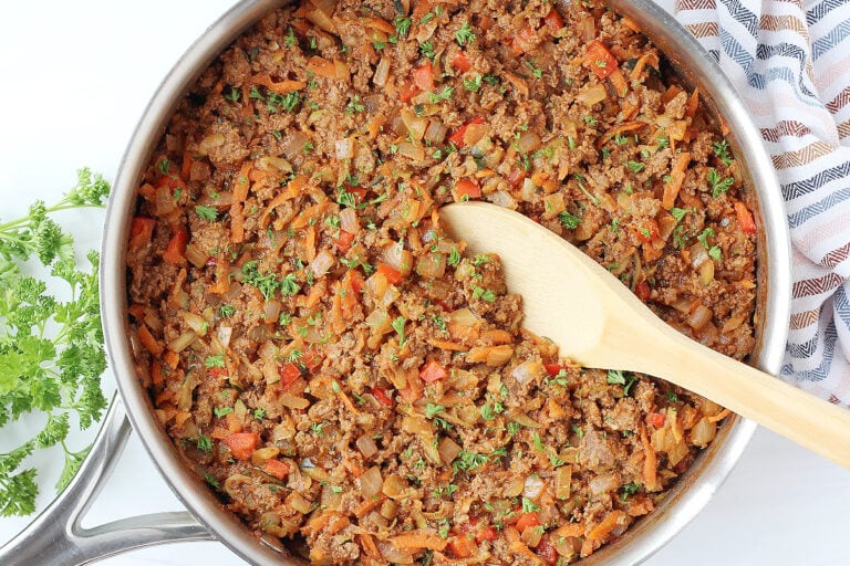 Overhead photo of healthy sloppy joes topped with fresh parsley with a wooden spoon.