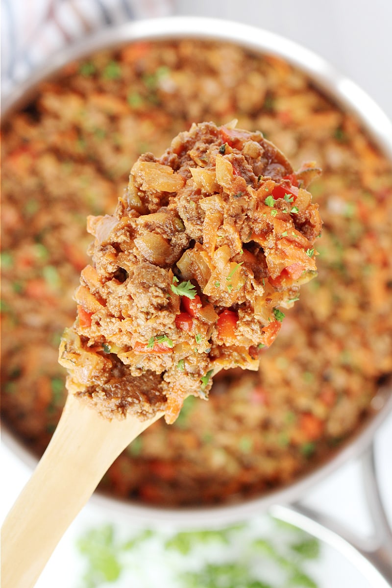 Overhead photo of a wooden spoon with healthy sloppy joes mix on it.