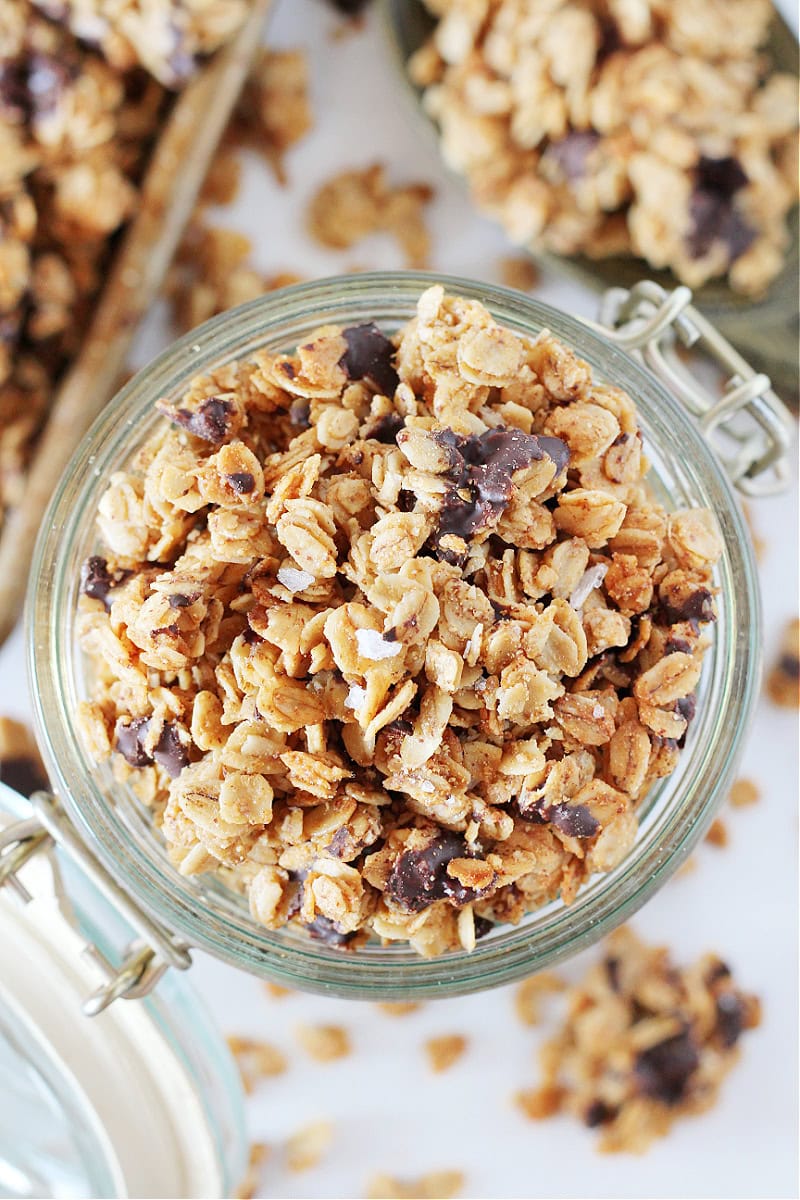 Overhead photo of salted dark chocolate granola in a glass jar with an attached lid.