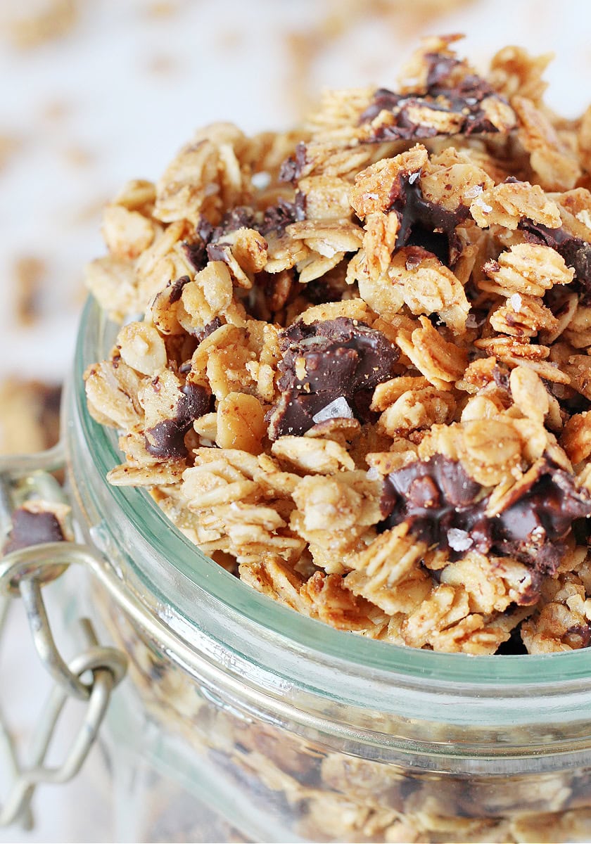 Up close side shot of salted dark chocolate granola in a glass jar.