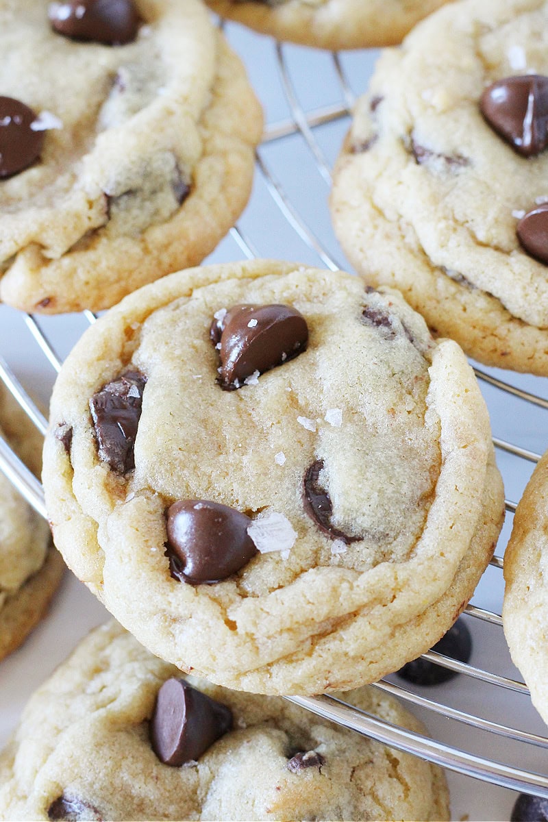 A close up of a chocolate chip cookie on a cooling rack.