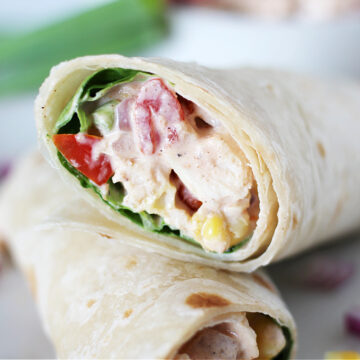 Up close photo of creamy bbq chicken salad in a tortilla with lettuce.