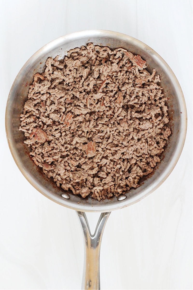 Overhead photo of browned ground beef in a stainless steel pan.