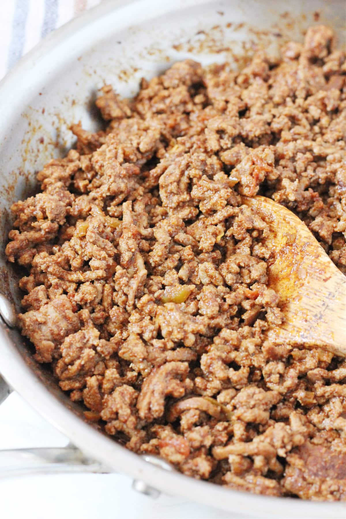 Up close photo of ground beef taco meat in a metal stovetop pan.