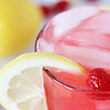 Up close photo of low sugar lemonade with a lemon slice and fresh raspberries.