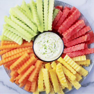 Overhead photo of four different kinds of fruit fries on a platter with yogurt dip.