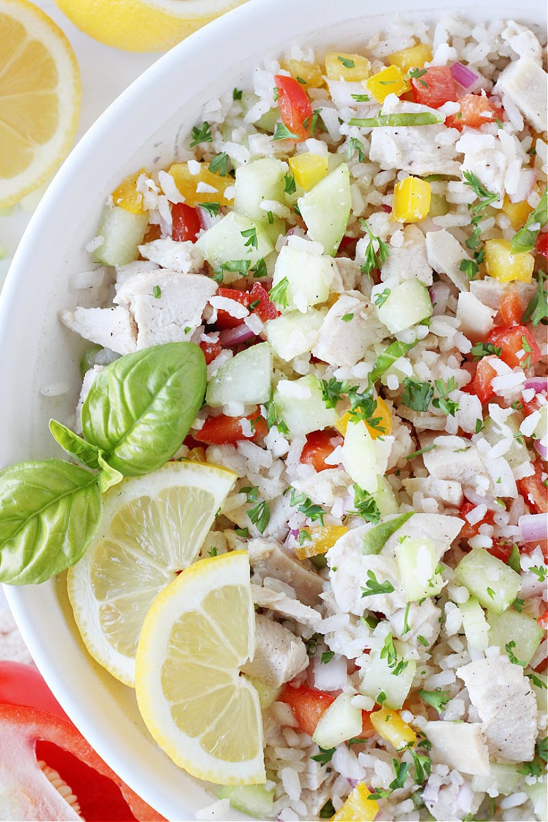 Overhead photo of a cold rice salad with diced chicken, vegetables with a lemon sauce.