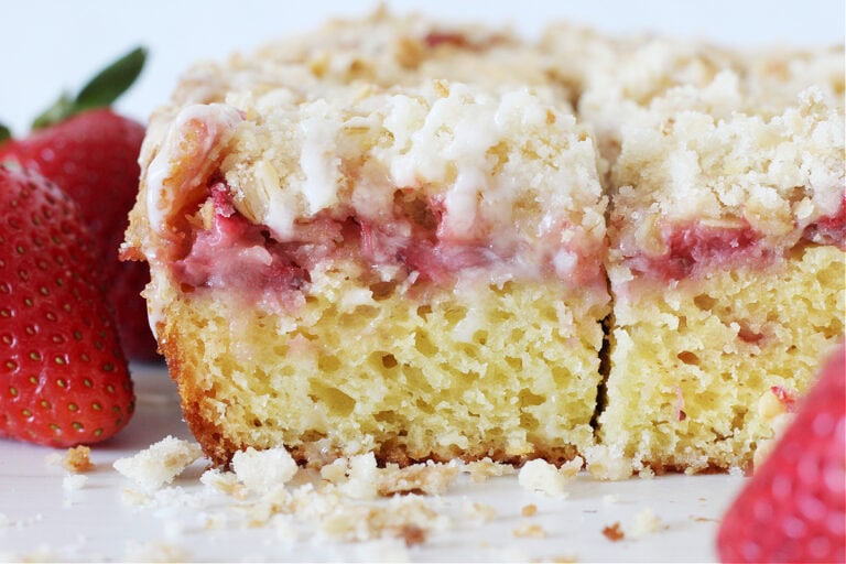 Up close side shot of the 3 layers of strawberry coffee cake with a glaze.