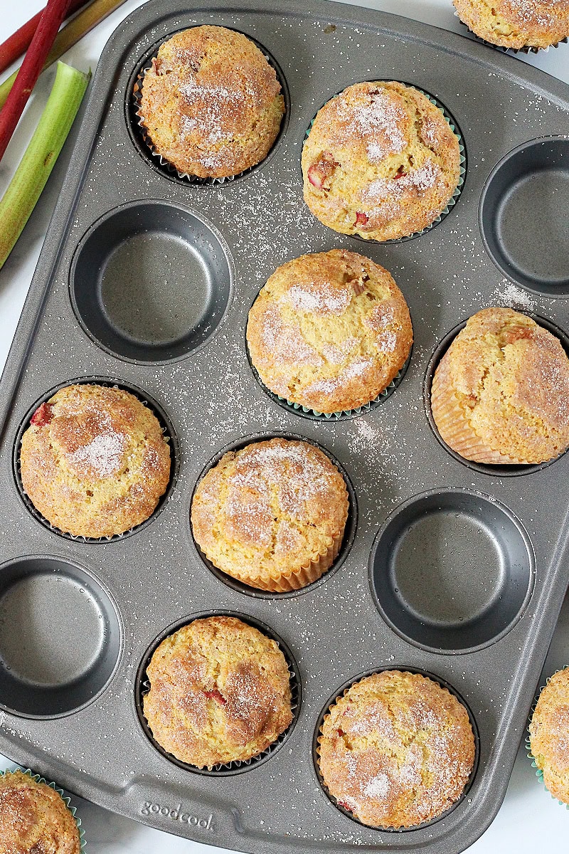 Rhubarb muffins sitting cattywampus on a muffin pan.