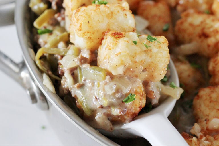 Tater tot casserole on a white silicone spoon.