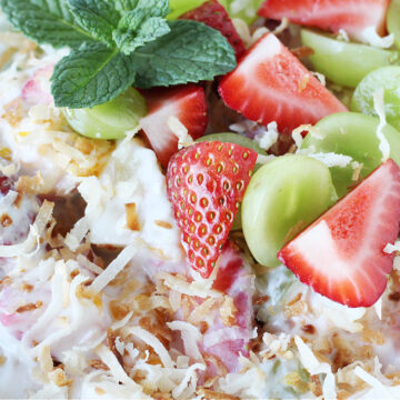 Up close photo of a summer fruit salad coated in coconut vanilla Greek yogurt.