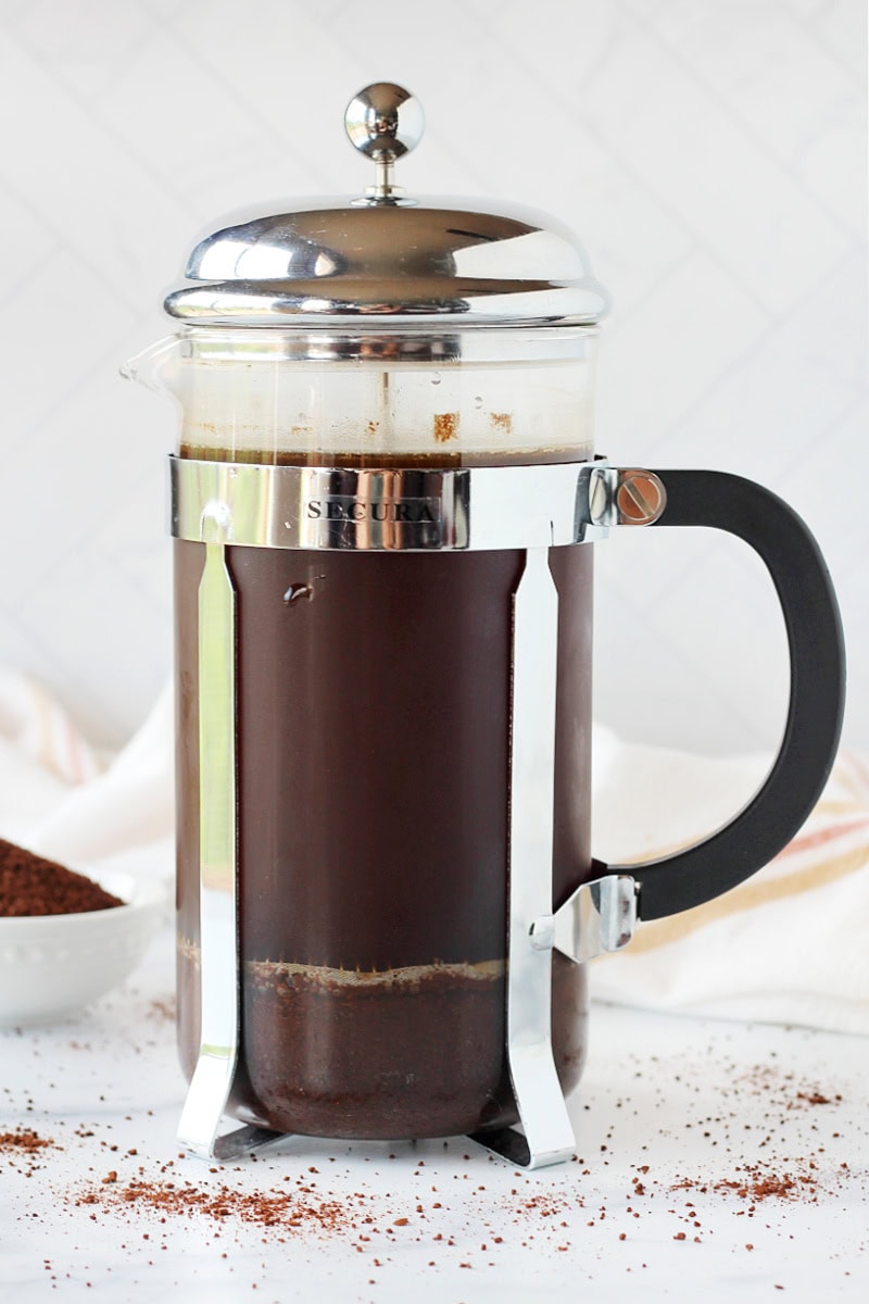 A French press with the plunger depressed for homemade cold brew.