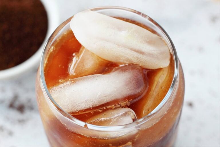 Overhead photo of ice cubes and cold brew in a clear glass.