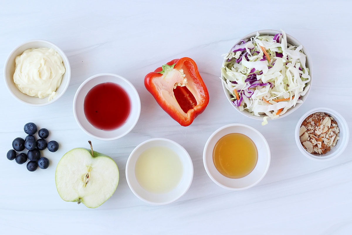 Ingredients on a white countertop for a red, white and blue cabbage salad.