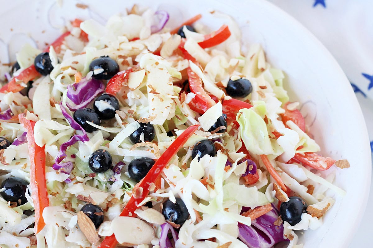 Up close photo of a patriotic coleslaw salad with blueberries and red bell pepper.