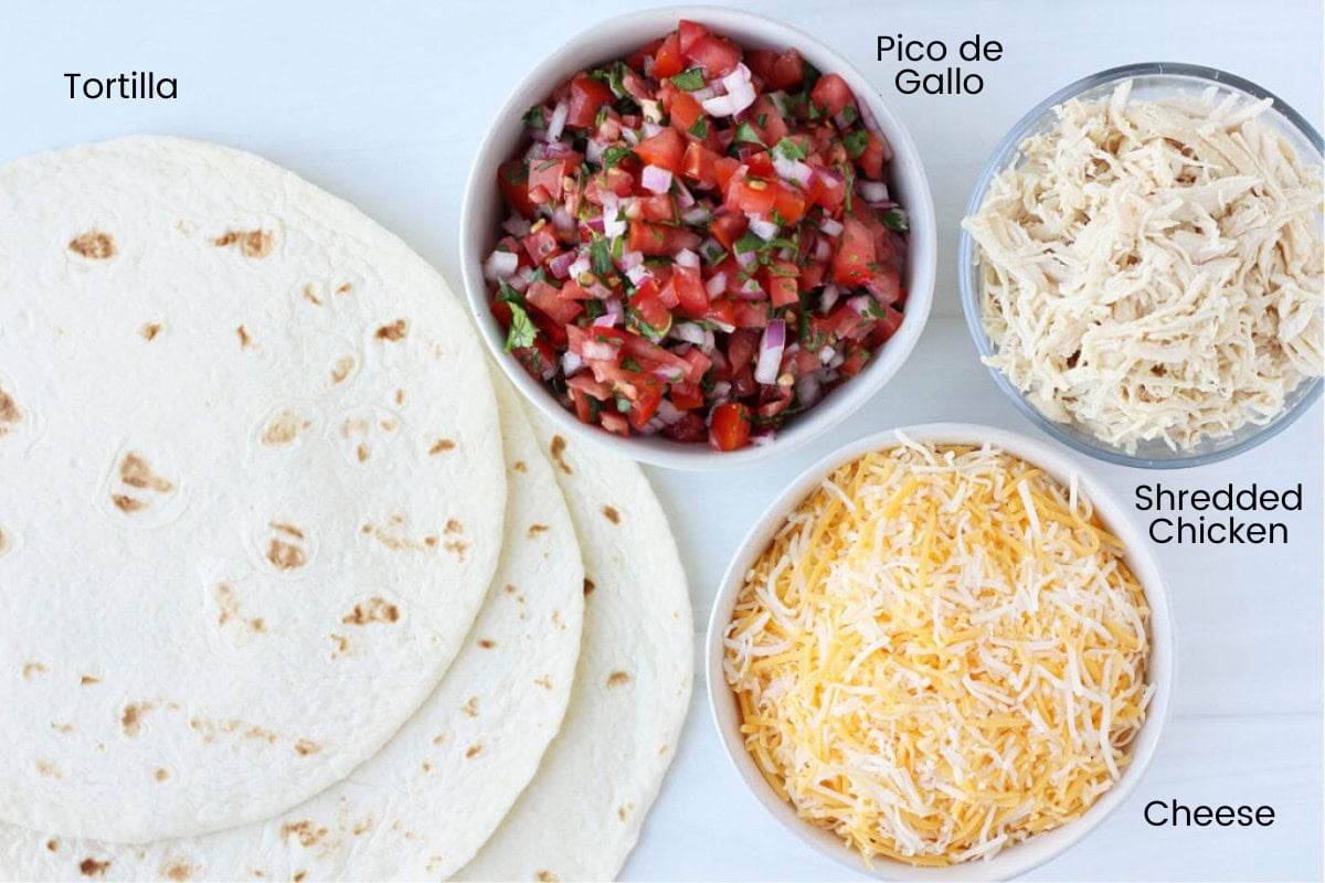 A stack of four slices of chicken quesadillas with pico on a white plate.