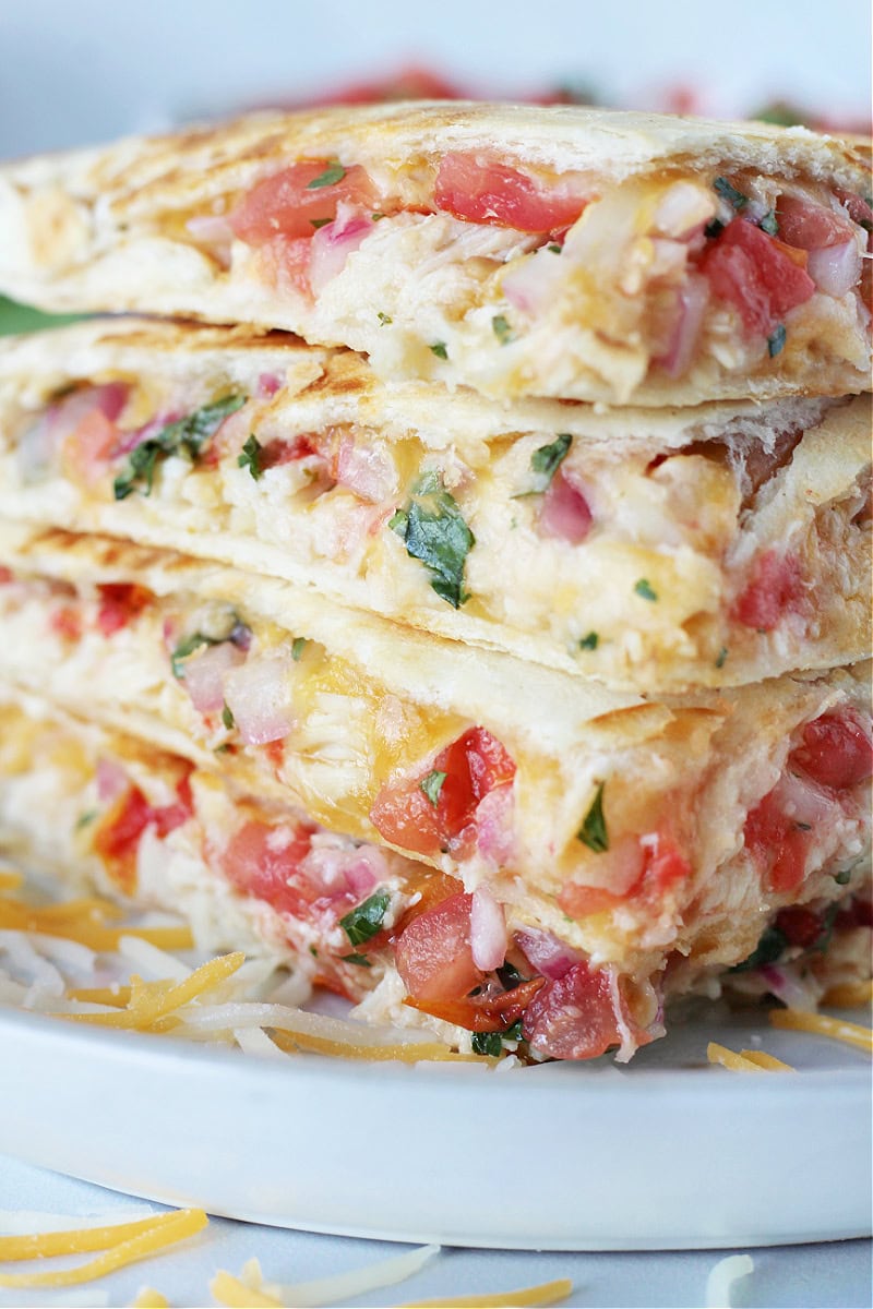 Up close photo a stack of quesadillas stuffed with chicken and pico de gallo.