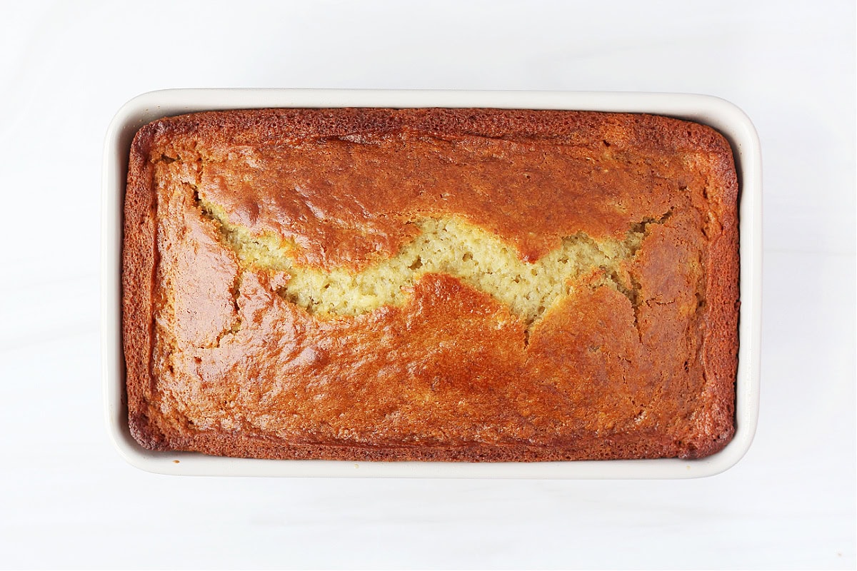 Overhead photo of a golden loaf of baked banana bread in the pan.