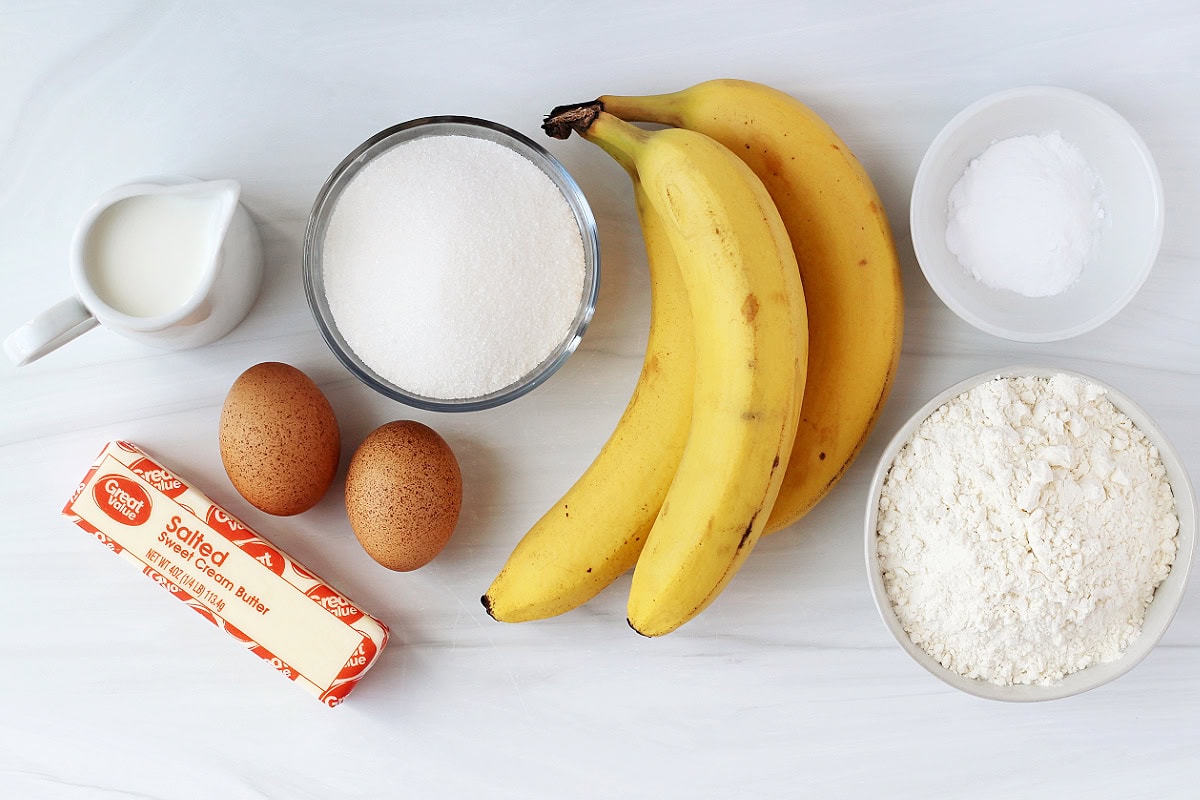 Three bananas, stick of butter, two eggs and other ingredients for banana bread.