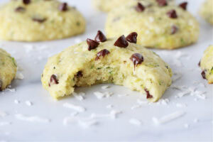 A zucchini cookie topped with chocolate chips with a bite taken out.