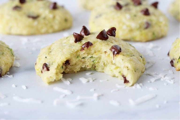 Photo of a zucchini cookie topped with chocolate chips with a bite taken out.