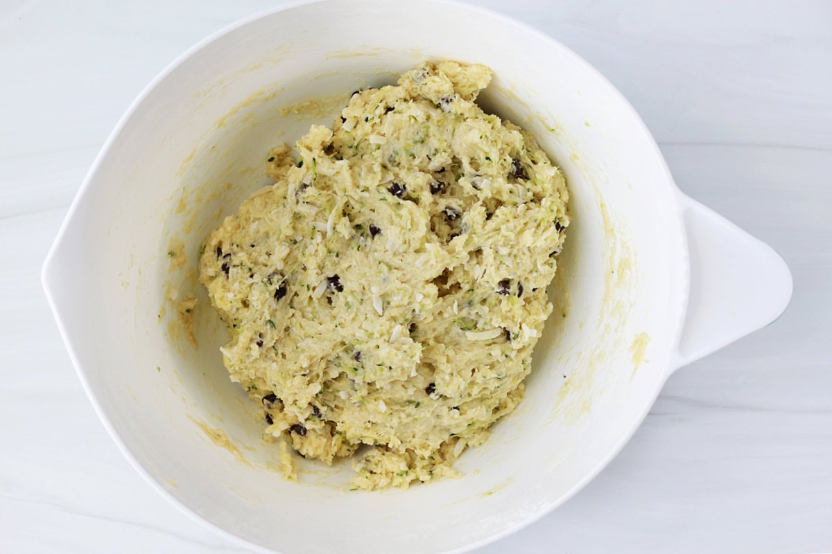 Chocolate chip zucchini cookie batter in a white mixing bowl.