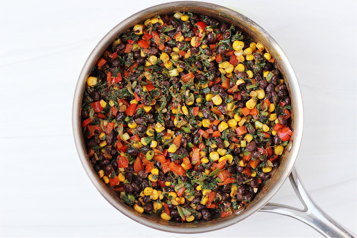 Overhead photo of vegan filling for southwest egg rolls in a stainless steel pan.