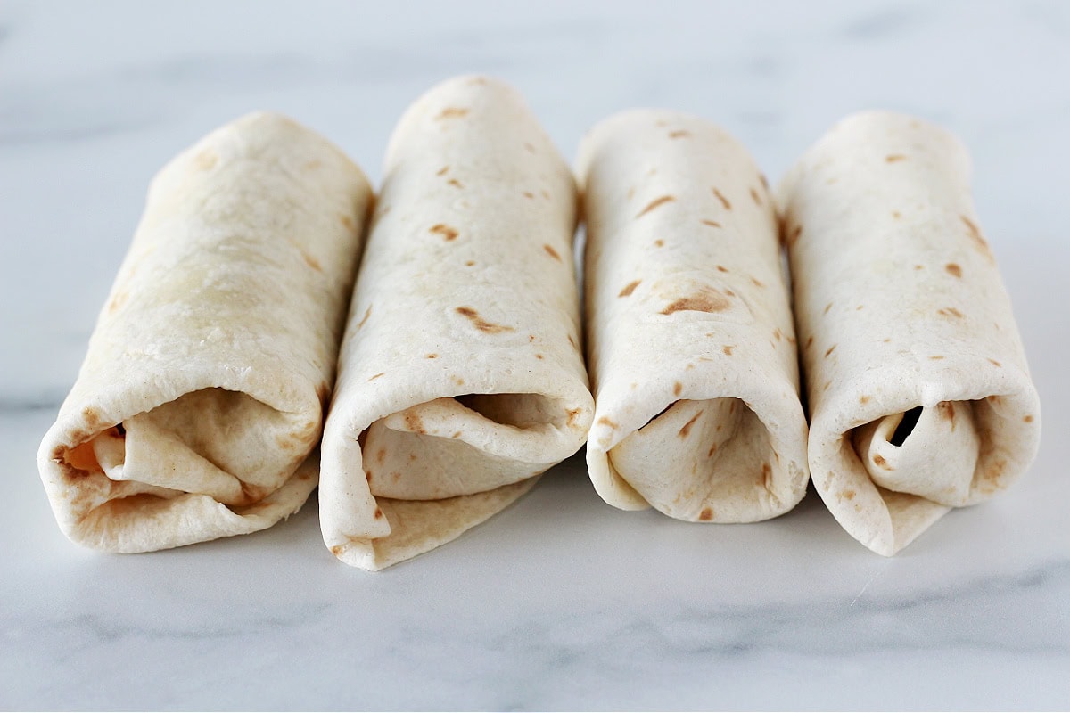 Four southwest egg rolls ready to be air fried.