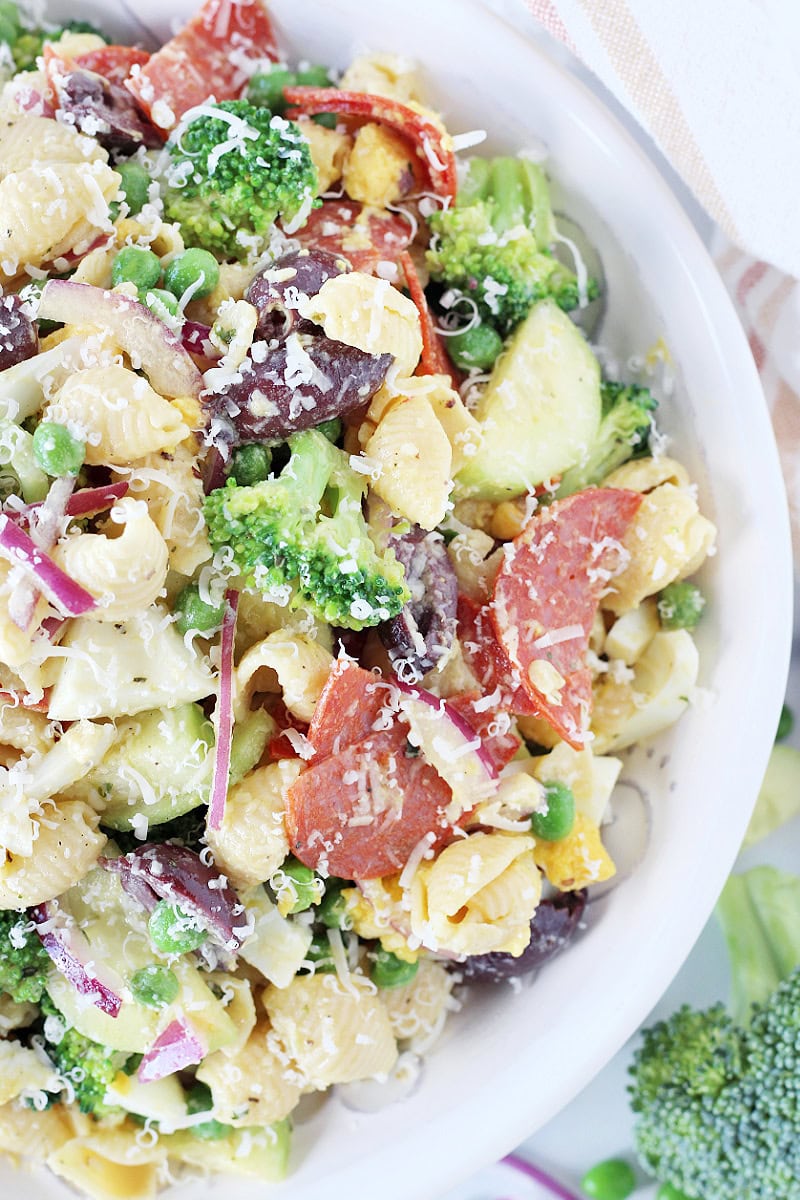 A high protein pasta salad in a white serving bowl topped with Parmesan cheese.